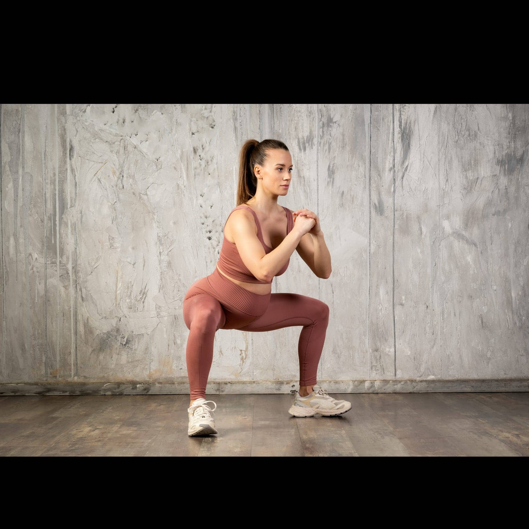 A pregnant person holding a strong, steady squat