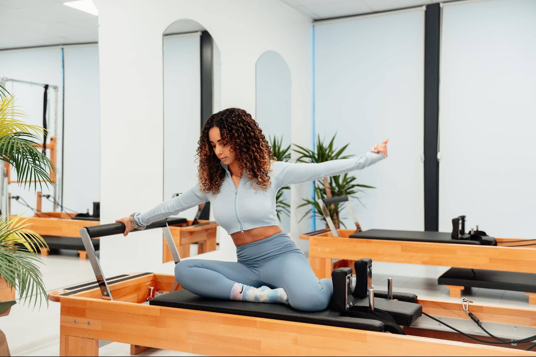 A person doing seated, supported control work on a reformer